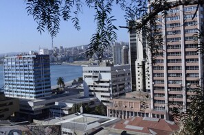 A cityscape with high-rise buildings, a waterfront, and a clear sky. - Hotel Brighton (Valparaiso)