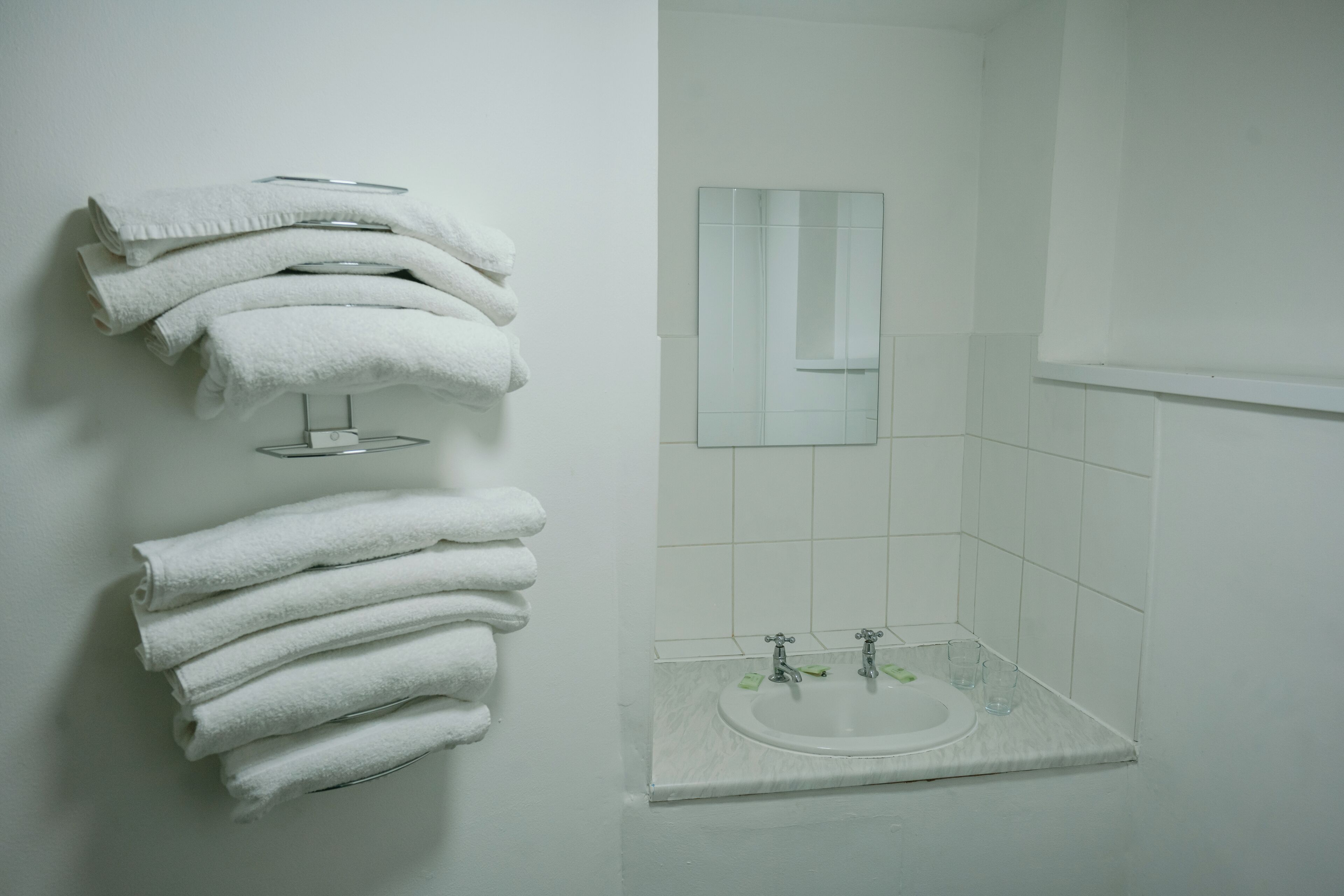 Ein Badezimmer mit Waschbecken, Spiegel und Handtüchern.