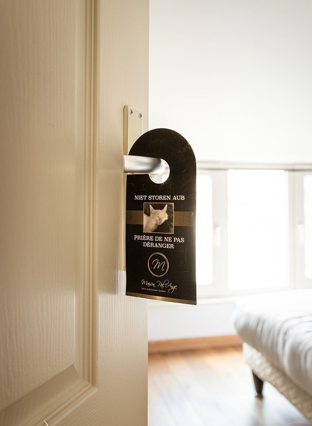 Une porte de chambre d’hôtel avec une pancarte indiquant « NE PAS DÉRANGER » et « PRIÈRE DE NE PAS DÉRANGER ».