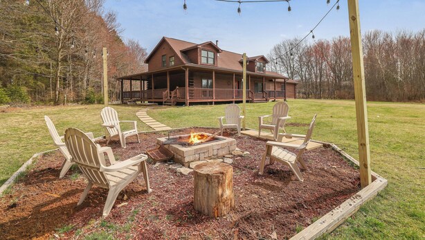 A lodge with a fire pit and outdoor seating. - Secluded & Tranquil Retreat for 14 in the Poconos – Firepit/Games/Stargazing+ (Lake Ariel)