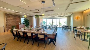 A spacious dining area with multiple tables and chairs, large windows, and a modern ceiling design. - Opera Suite hotel Pesaro (Pesaro)