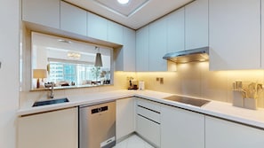 A modern kitchen with a dishwasher, a sink, and a stove hood. - Beautiful 2 Bed l Modern Amenities l Marina Views (Dubai Marina)