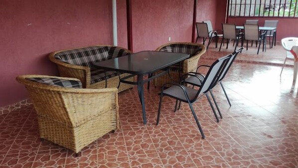 A covered outdoor seating area with wicker furniture and a tiled floor. - Barracuda Resort (Homa Bay)