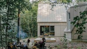 Een modern huis met terras, omringd door bomen.