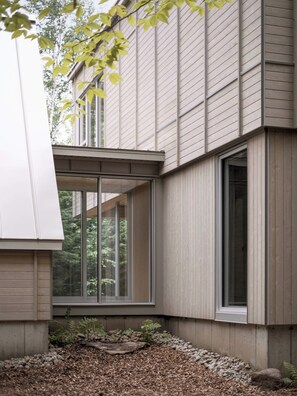 A modern building with large windows, a stone foundation, and a wooden exterior. - The Shoal (Lanaudière)