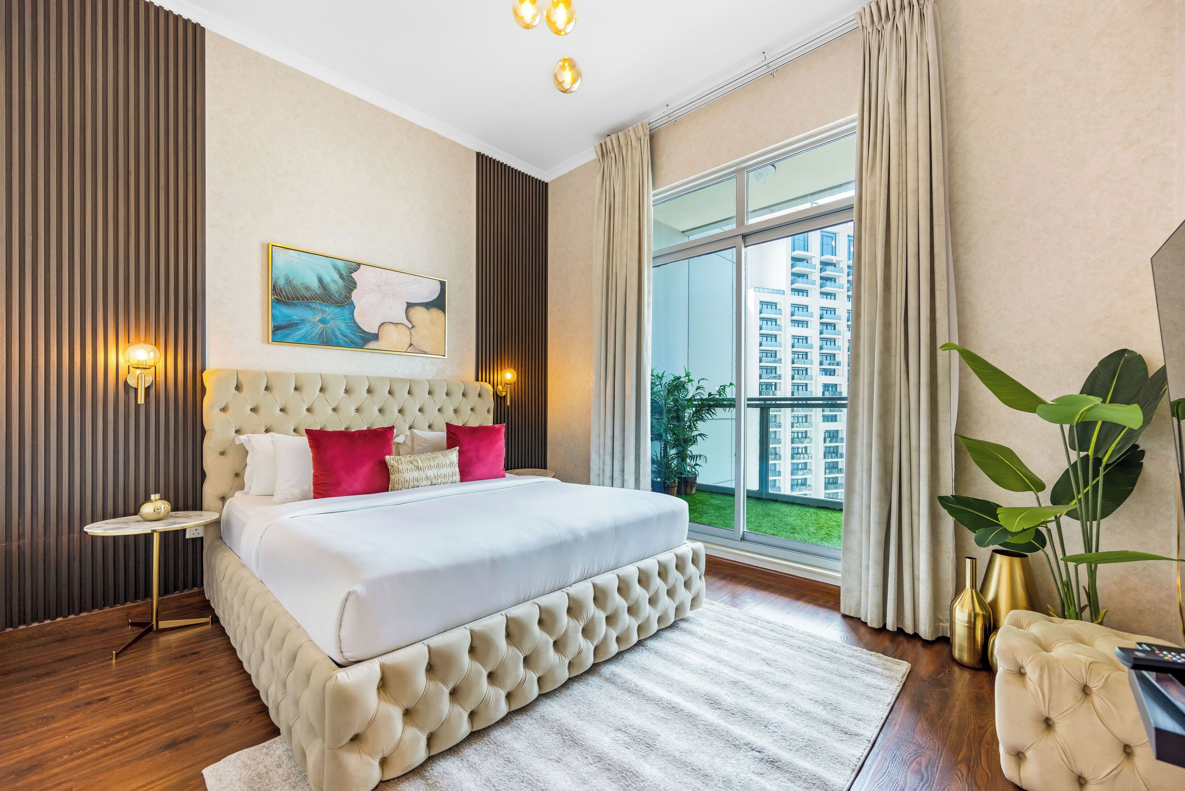 A spacious bedroom with a large bed, a view of a building through the window, and a potted plant.