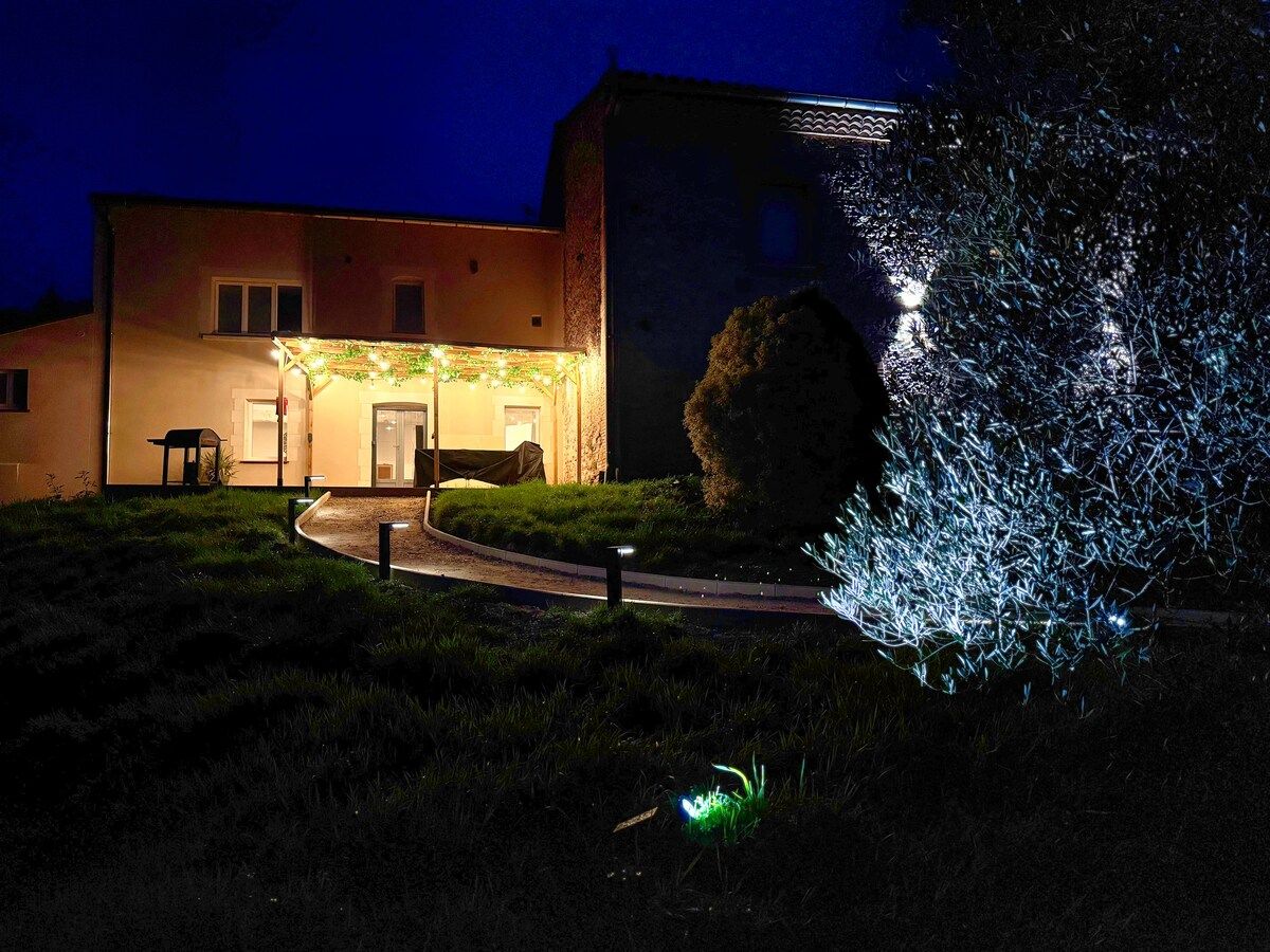 Een gebouw met een goed verlichte ingang, een geplaveid pad en een klein zitje.