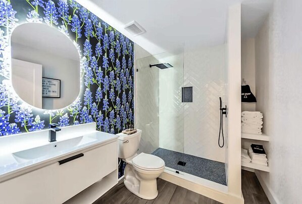 A modern bathroom with a white sink, toilet, and shower area. - Bell Mare Hotel (Breckenridge)