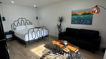 Un dormitorio moderno con cama, mesita de noche y una alfombra con estampado de cebra.