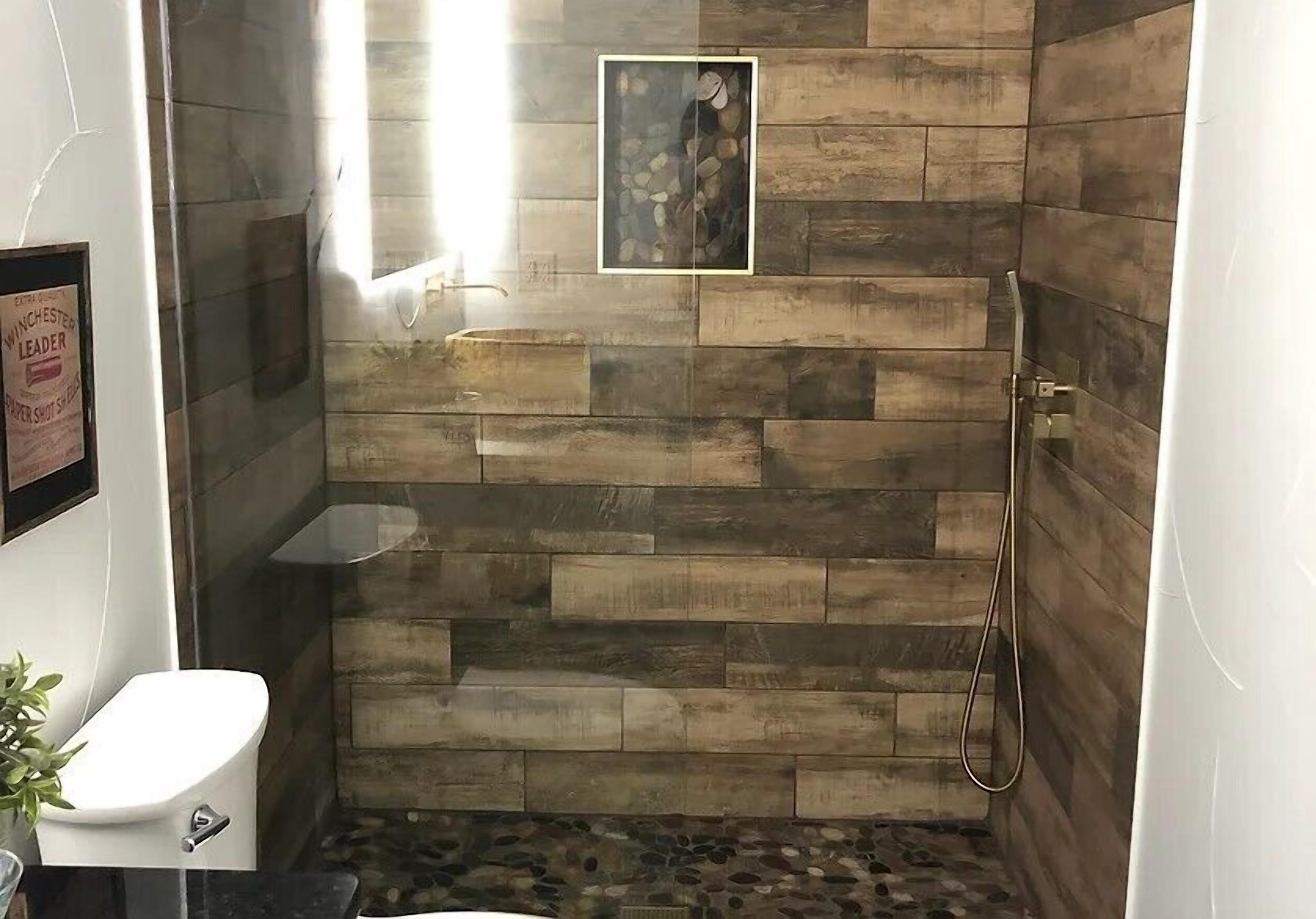 A bathroom with a shower area, a toilet, and a framed picture on the wall.