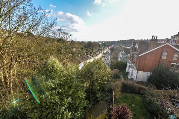 A residential area with terraced houses, a garden, and a clear sky. - Luxury Hastings Apartment (Hastings)