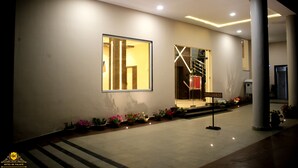 A hotel entrance with a modern design, including a large window, a staircase, and a 'No Parking' sign. - HOTEL GK PALACE (East Jorhat)