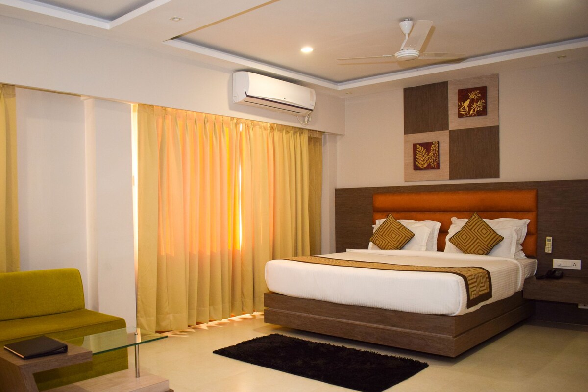 Une chambre d’hôtel moderne équipée d’un lit, d’un canapé, d’une table basse et d’un appareil de climatisation.