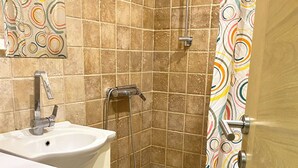 Ein Badezimmer mit Dusche, Waschbecken und Toilette.