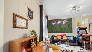Ein modernes Wohnzimmer mit einer Couch, einem Couchtisch und einer Spielhalle.