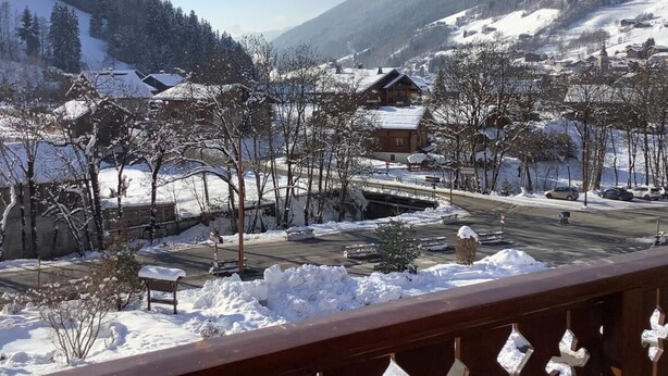 A snowy mountain village with buildings and a road.