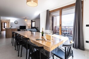 Eine moderne Küche mit einer Holztischinsel, Barhocker und einem Esstisch.