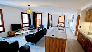 A modern open-plan living area with a kitchen, dining space, and seating area. - 50m from ski slopes, balcony, tv, 115m², Montalbert (La Plagne)