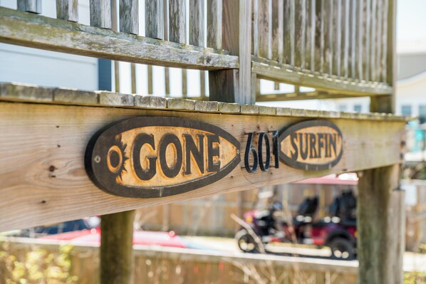 Une structure en bois sur laquelle on peut lire les inscriptions « FERMÉ » et « SURFIN ».