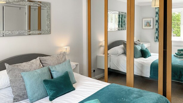 Ein Hotelzimmer mit einem Bett, einem Spiegel und einem Fenster.