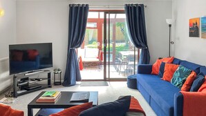 Ein Wohnzimmer mit Fernseher, Sofa und Couchtisch.