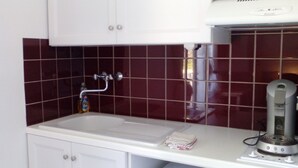 A kitchen with a white countertop, a sink, a dish soap bottle, and a coffee machine. - Cozy studio with air conditioning; secure parking; countryside near the city (Avignon)