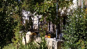 A stone wall with potted plants and a metal fence in a garden area. - Cozy studio with air conditioning; secure parking; countryside near the city (Avignon)