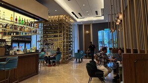 A modern bar area with a wine and liquor display, seating, and a counter. - Well-Shaped Suites At STAR KLCC (Kuala Lumpur)