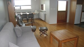Una sala de estar con un sofá, una mesa de centro de madera y un comedor con sillas y una mesa.