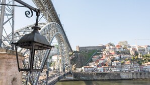 A bridge with a street lamp, a river, and a historic town with buildings. - GuestReady - Charming Retreat near the Cathedral (Vila Nova de Gaia)