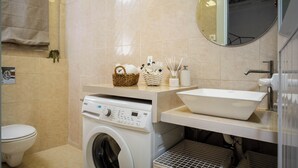 A modern bathroom with a washing machine, sink, and mirror. - Charming 1-bedroom apartment with WiFi, AC in gorgeous Jerusalem (Jerusalem)