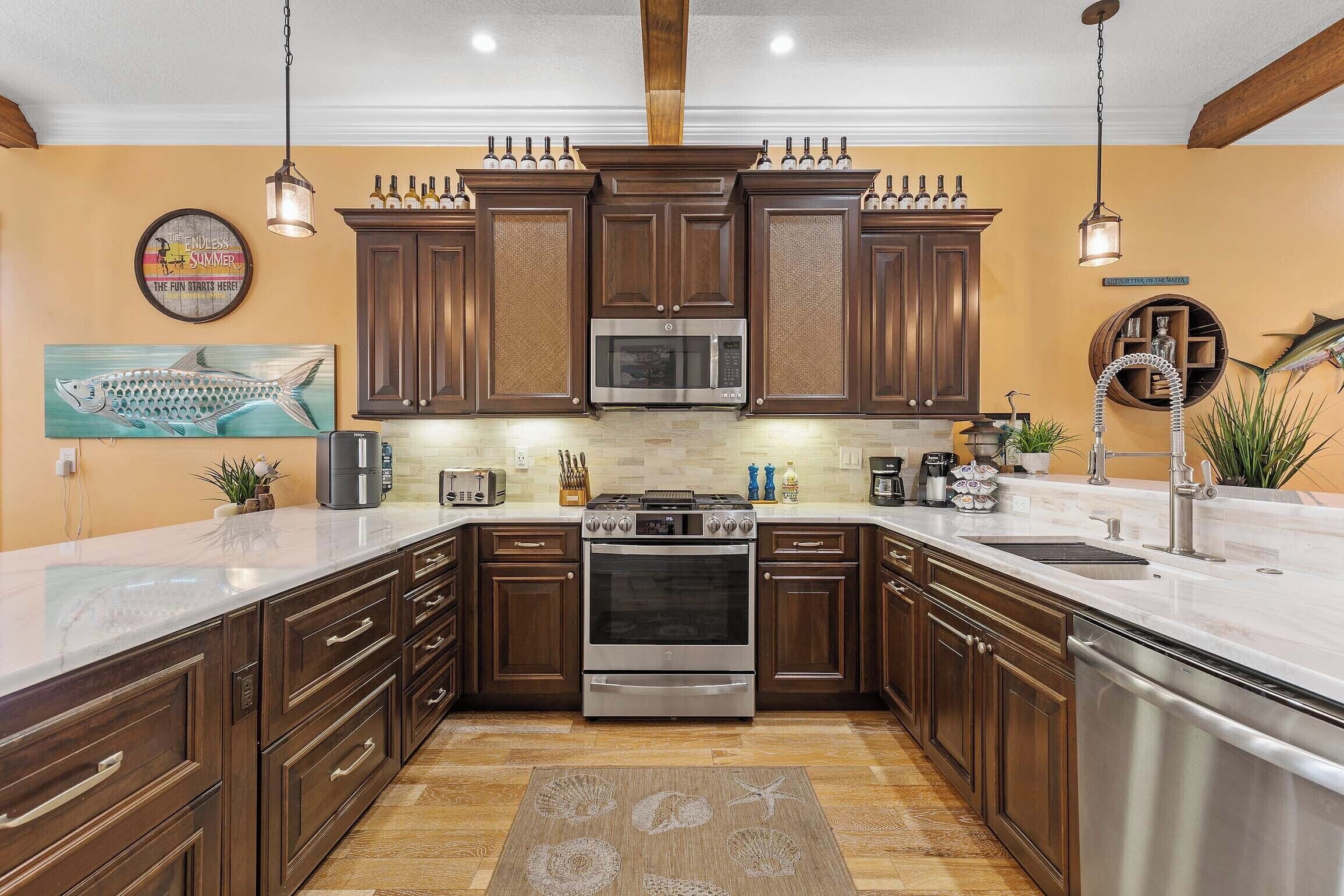 A kitchen with dark wooden cabinets, stainless steel appliances, and a white countertop.