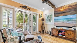Un salón con un televisor grande, muebles de madera y una estantería.