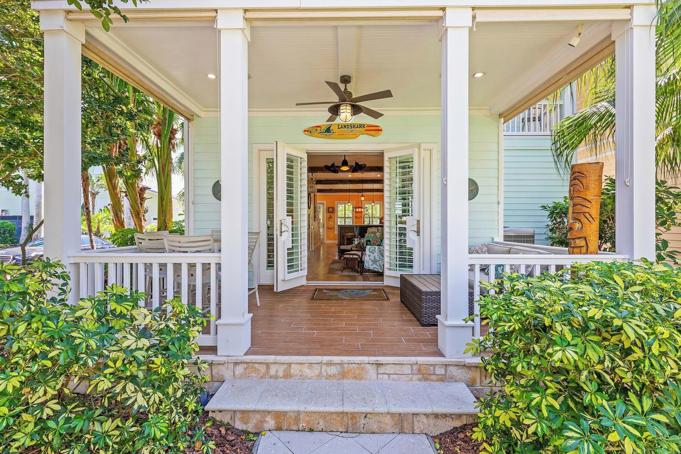 A covered porch with a ceiling fan, a sign reading "Landshark," and a view into the interior.