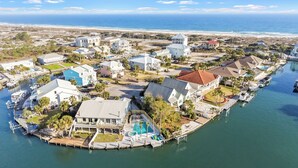 A coastal residential area with houses, a marina, and a beach in the background. - Captain's Cove 4BR 3Bath  Water View, Pickleball, Private Beach, Heated Pool! (Pensacola)