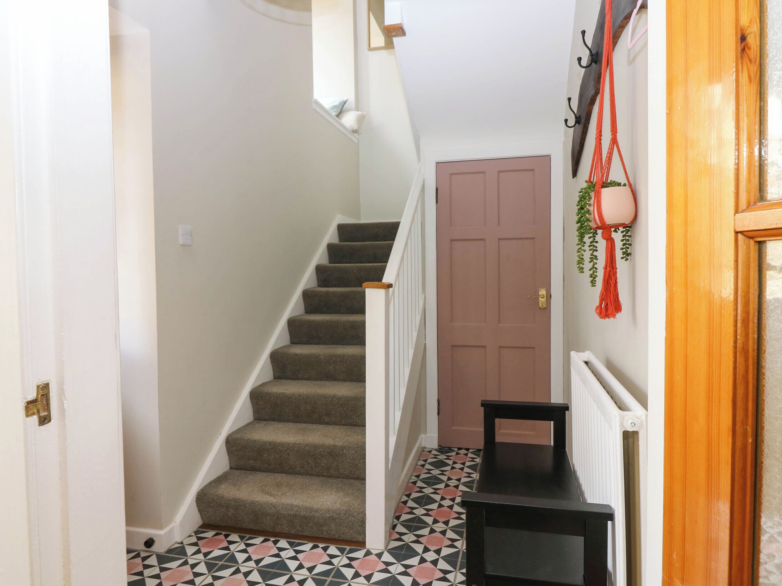 A staircase with carpeted steps, a wooden door, and a radiator.