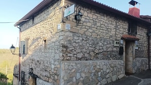 Un edificio de piedra con aspecto rústico, con un cartel que dice "Calle Truesana" y una pequeña entrada.
