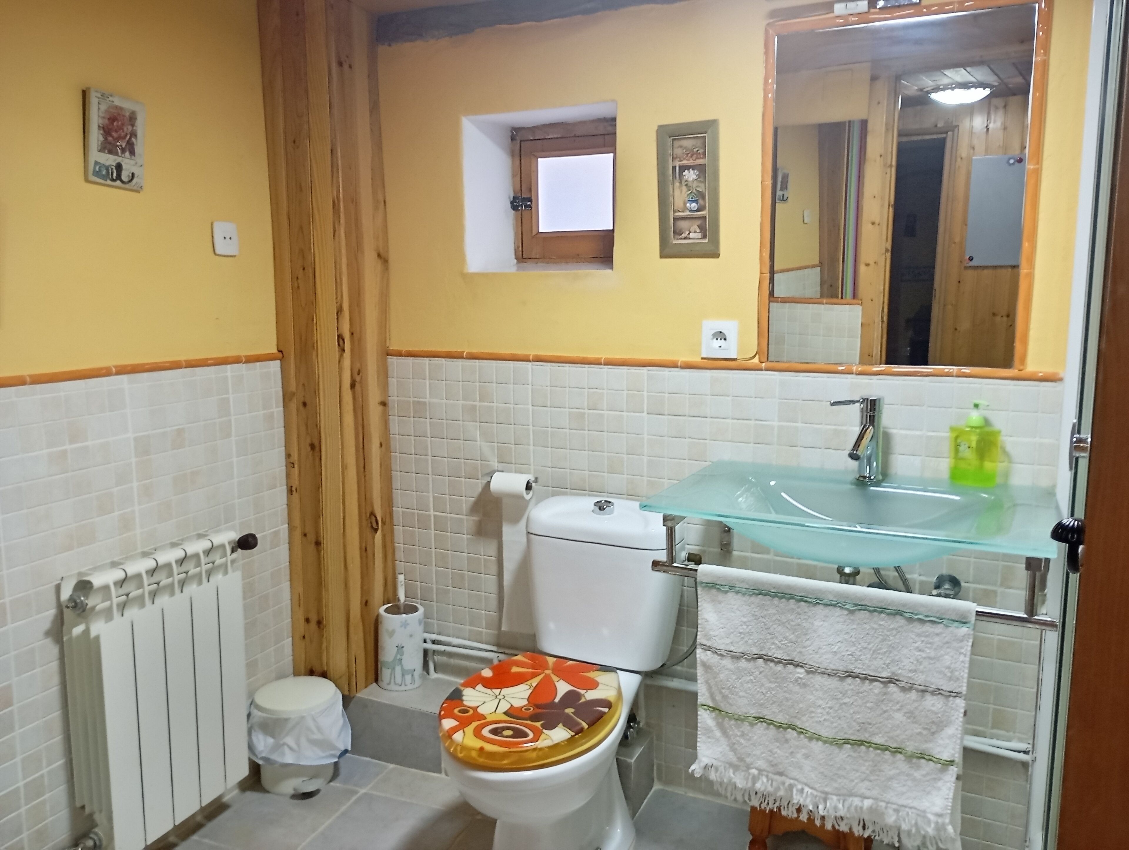 Un baño con inodoro, lavamanos y espejo.