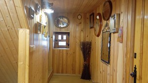 Un interior de madera con una escalera, espejos en la pared y un ventanal pequeño.