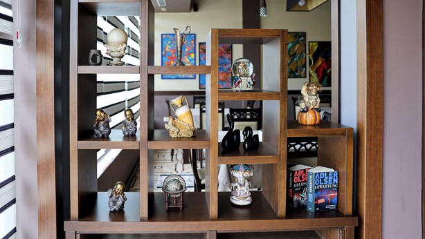 A wooden shelving unit with various decorative items and books. - Opus Hotel (Berat)