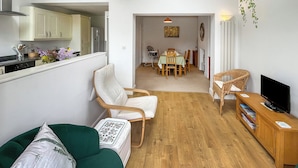 Un espacio habitable moderno con comedor, cocina y televisor.