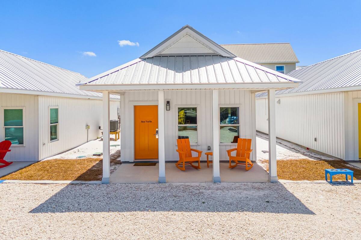 A building with a covered porch, orange rocking chairs, and a door labeled "Sea Turtle".