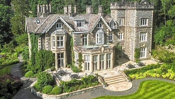 A large stone manor with multiple chimneys, surrounded by lush greenery and a well-maintained lawn. - Forest Side Hotel (Ambleside)