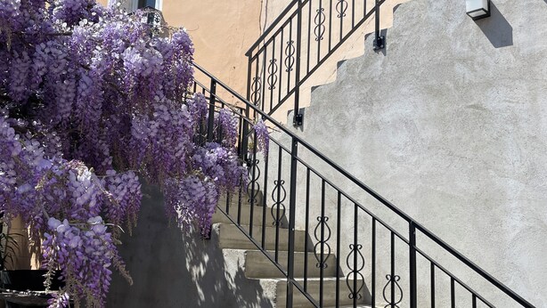 A staircase with a wrought iron railing leading up to a building with a beige exterior and a window. - The studio with its large, unoverlooked terrace, in a quiet location with private parking (Saint-Estève)