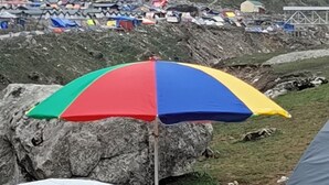 A mountainous campsite with tents and a colorful umbrella. - YATRA DHAM CAMP KEDARNATH  (Kedarnath)