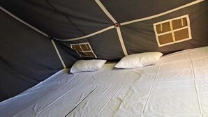 A tent with a bed, pillows, and a window. - YATRA DHAM CAMP KEDARNATH  (Kedarnath)