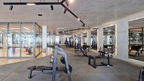 A modern gym with glass walls, various exercise equipment, and a clean, spacious layout. - COARM0106 - Edificio Art Studio (Salvador)