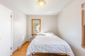 A bedroom with a bed, a window, a bedside table, and a ceiling light. - 4 bedroom HOUSE – 5 Minutes to MOA & AIRPORT (Minneapolis)