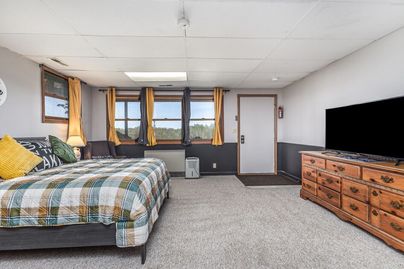 Une chambre d’hôtel équipée d’un lit, d’un bureau, d’une commode et d’un téléviseur.