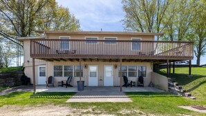 Een gebouw met twee verdiepingen, een overdekt terras, zitplaatsen buiten en uitzicht op het omliggende landschap.